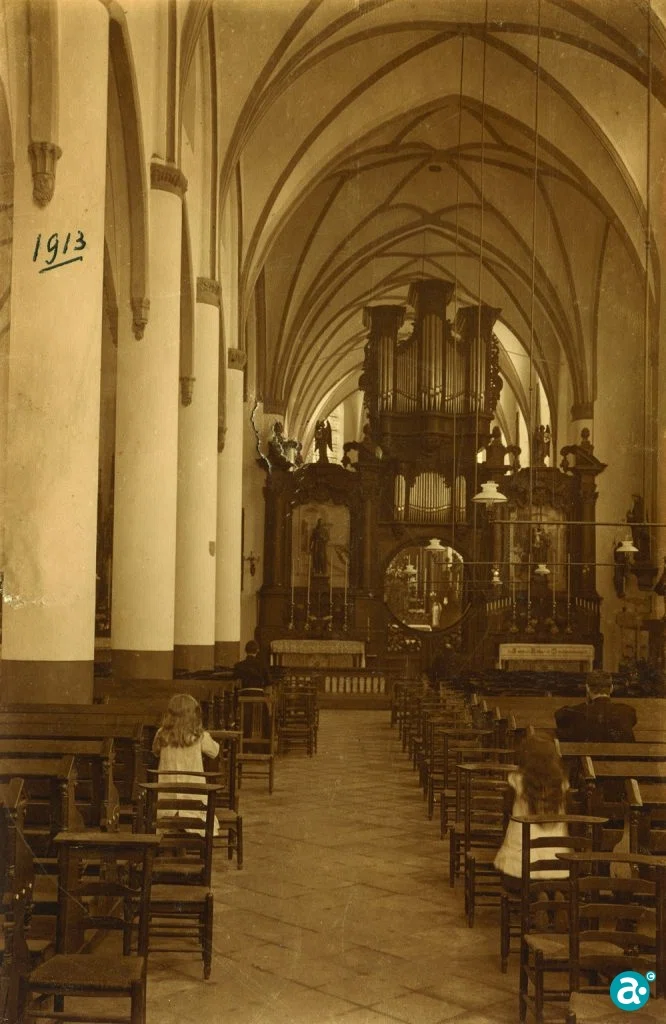 Historisch interieur van de Paterskerk met pijlers, gewelven en kerkbanken